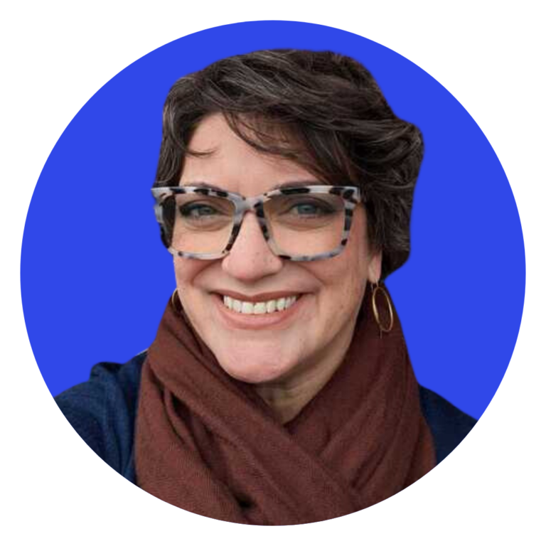 Smiling white woman with short brown hair, tortiseshell reading glasses, maroon scarf, and navy blue sweater on a circular bright blue background.